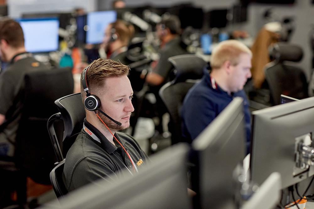 Man sitting at a computer in a support team Man sitting at a computer in a support team